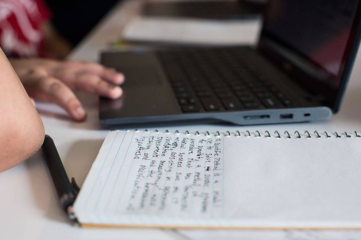 People working with a computer and a note book